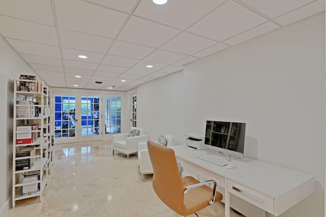 office featuring built in desk, a paneled ceiling, and french doors