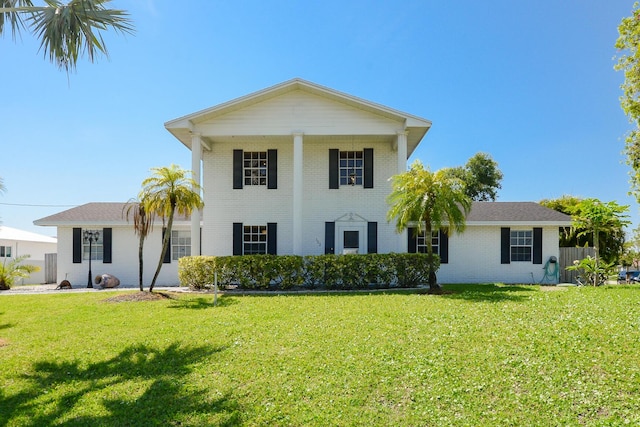 view of front facade featuring brick siding and a front yard