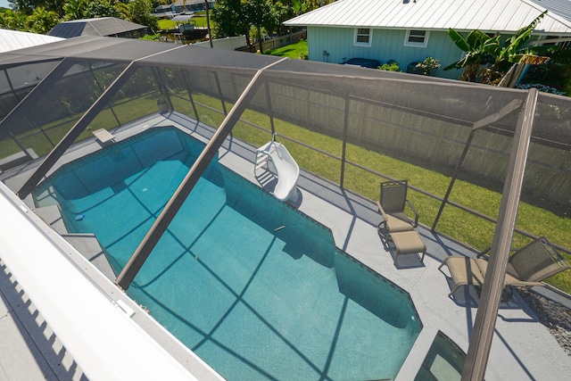 outdoor pool with a water slide and glass enclosure