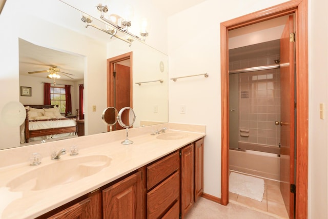 ensuite bathroom with double vanity, a ceiling fan, and bath / shower combo with glass door