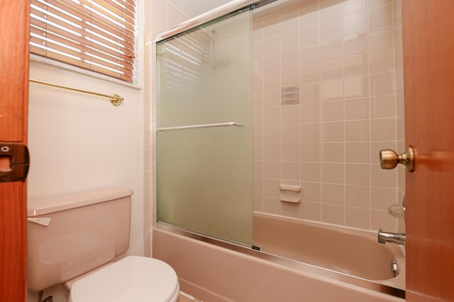 full bath featuring toilet and shower / bath combination with glass door
