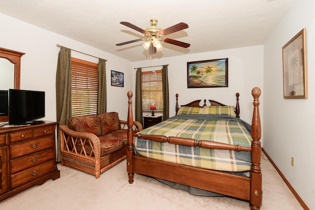bedroom with light carpet, ceiling fan, and baseboards