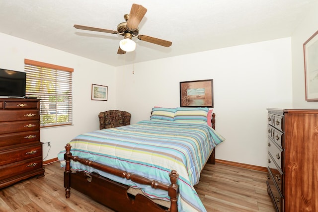 bedroom with light wood-style flooring, baseboards, and ceiling fan