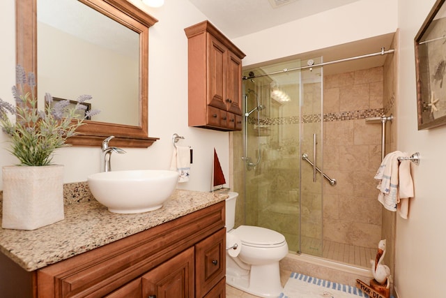 full bathroom featuring a stall shower, vanity, toilet, and tile patterned flooring
