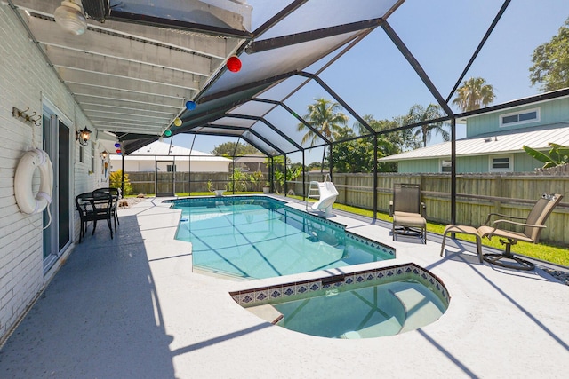 view of swimming pool with an in-ground hot tub, a patio area, a fenced backyard, and glass enclosure
