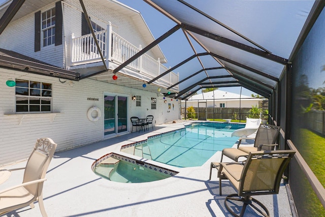 view of pool with a patio area, a lanai, and a pool with connected hot tub