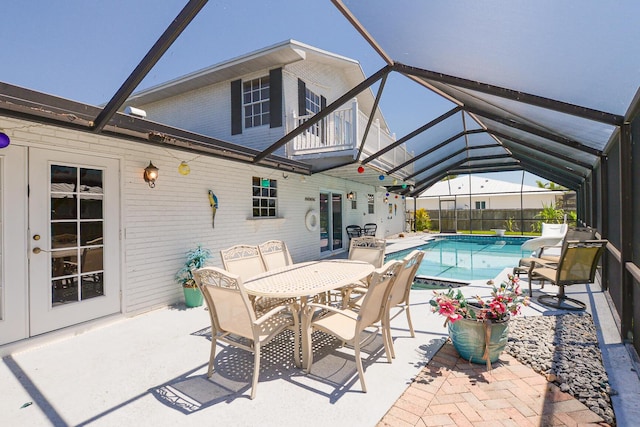 view of patio with glass enclosure and outdoor dining area