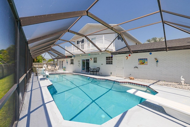 view of pool featuring a patio area, glass enclosure, and a diving board