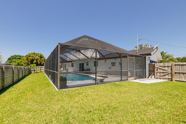 back of property with a patio, a gate, and glass enclosure