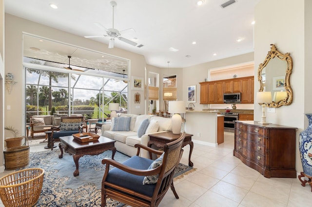 living room with light tile patterned floors, visible vents, a ceiling fan, a sunroom, and recessed lighting