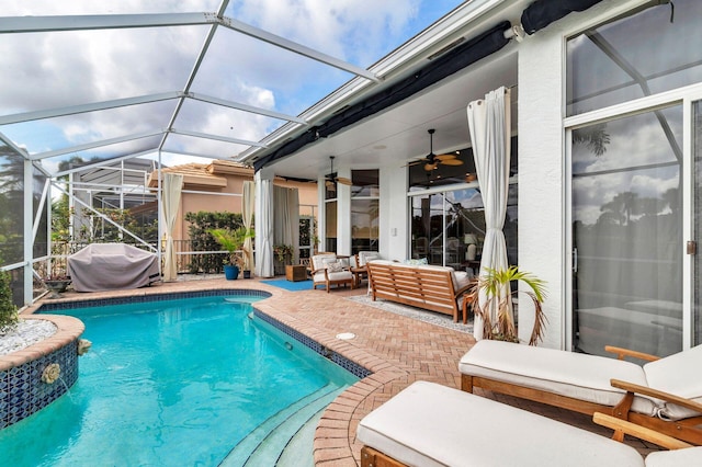 view of swimming pool featuring a patio area, grilling area, glass enclosure, ceiling fan, and an outdoor hangout area