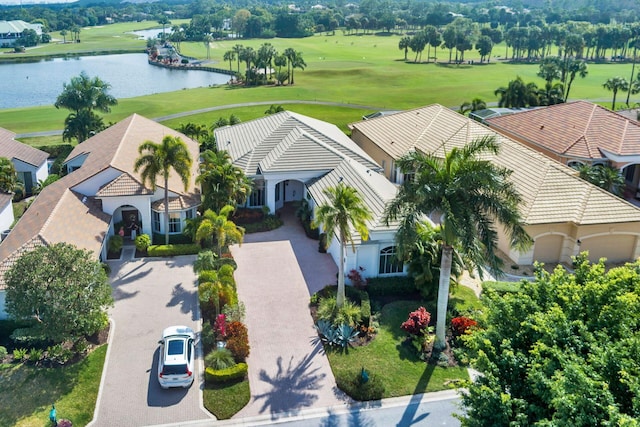 birds eye view of property with golf course view and a water view