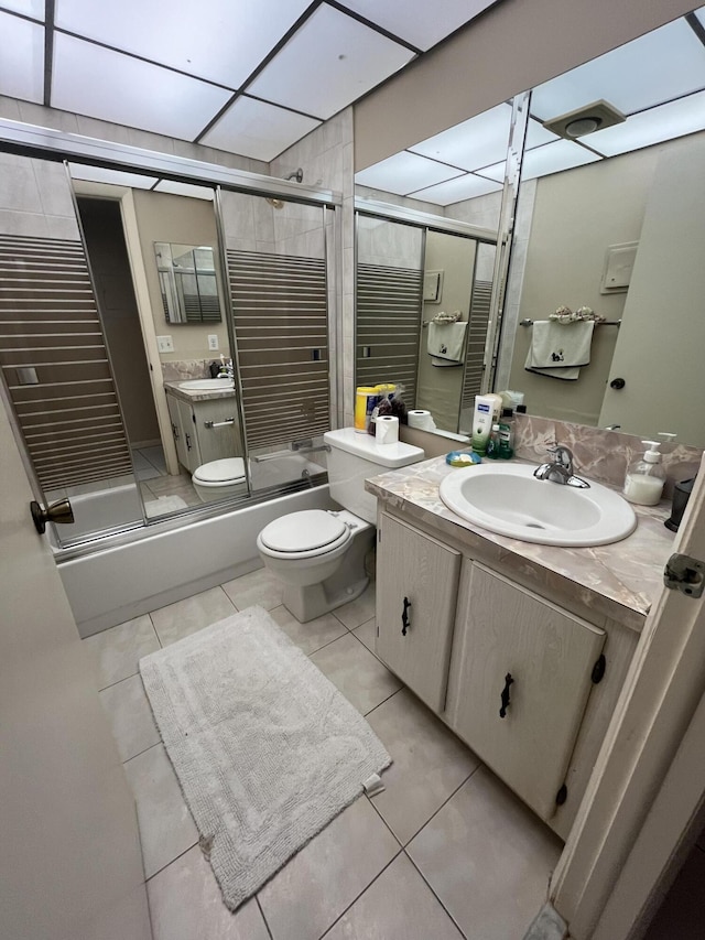 full bathroom featuring vanity, toilet, tile patterned flooring, and combined bath / shower with glass door