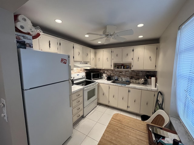 kitchen featuring sink, white appliances, light tile patterned floors, and decorative backsplash