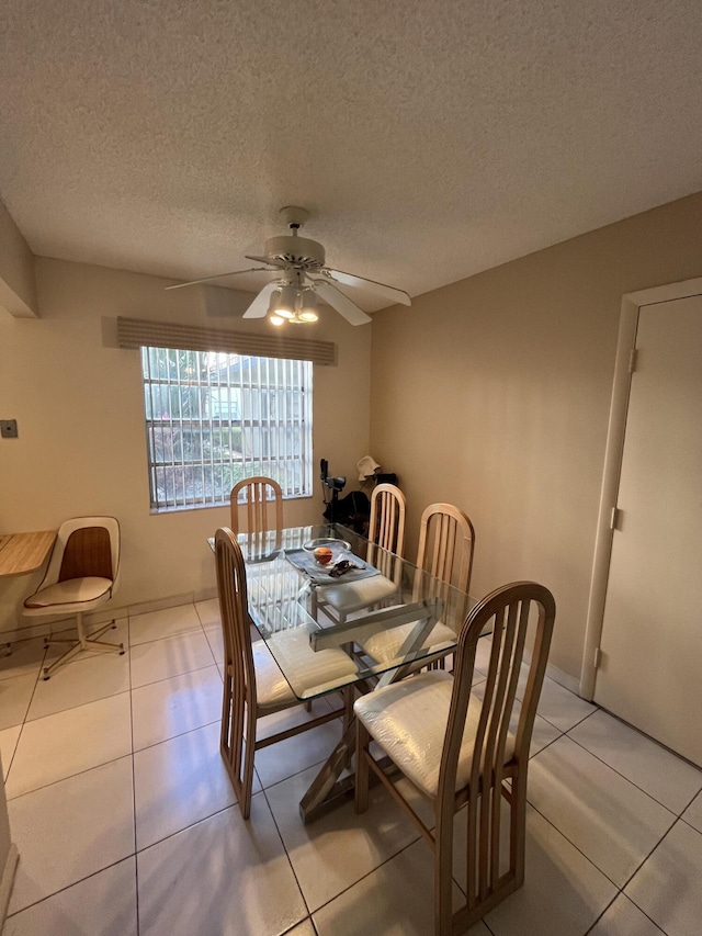 tiled dining area featuring a textured ceiling and ceiling fan