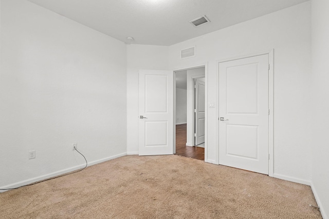 unfurnished room featuring carpet floors, baseboards, and visible vents