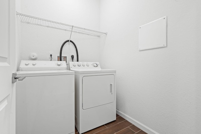 laundry area featuring wood tiled floor, laundry area, independent washer and dryer, and baseboards