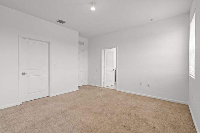 unfurnished bedroom with light carpet, baseboards, and visible vents