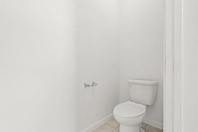 bathroom with toilet, tile patterned flooring, and baseboards