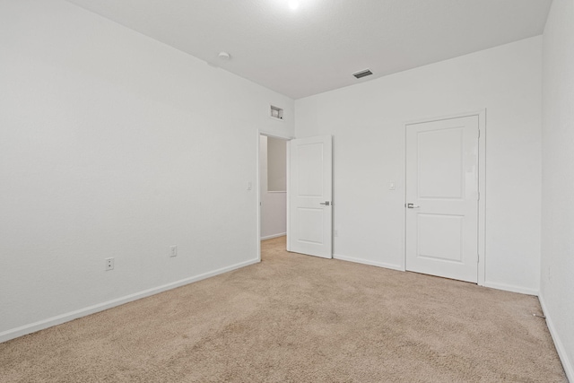 unfurnished bedroom with carpet, visible vents, and baseboards