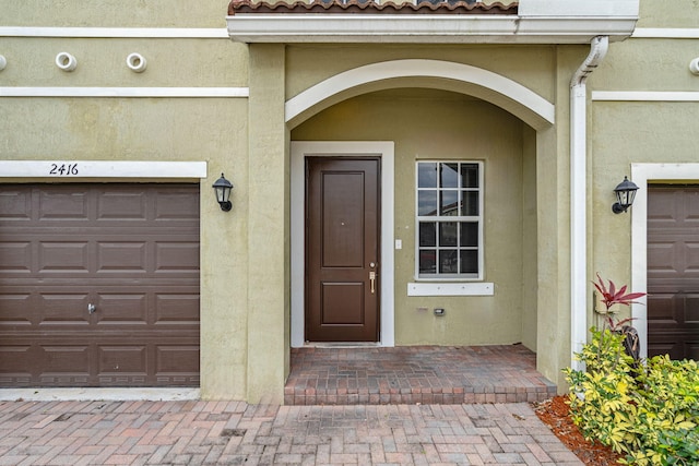 property entrance featuring a tiled roof and stucco siding