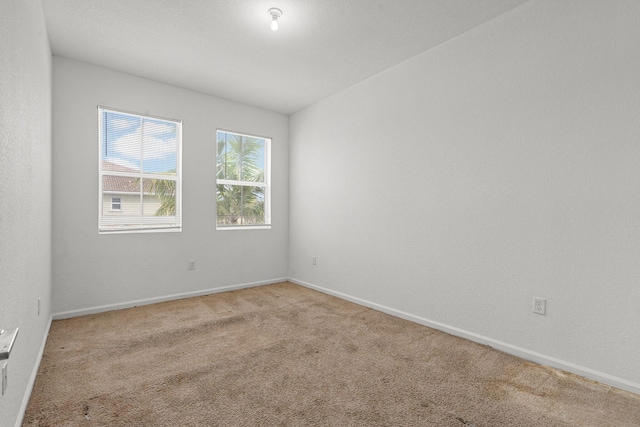 carpeted empty room with baseboards