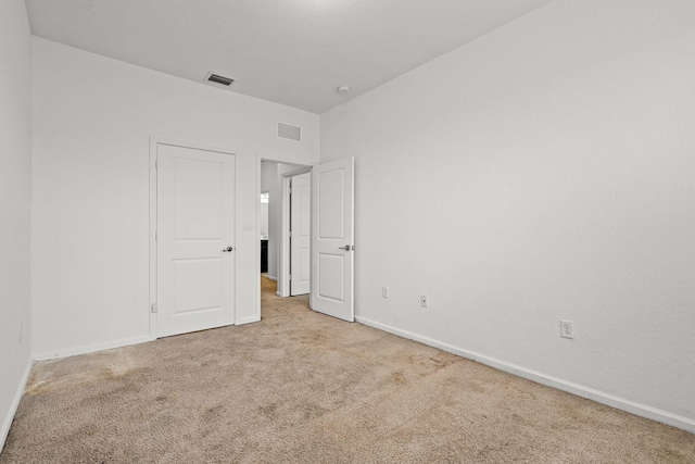 unfurnished room featuring carpet, visible vents, and baseboards