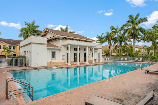 pool with a patio area and fence