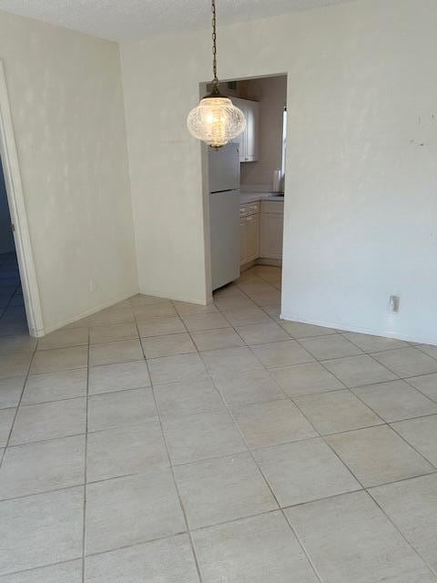 tiled empty room with a textured ceiling