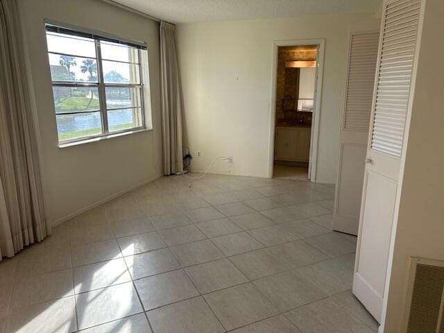 unfurnished room featuring light tile patterned flooring and a textured ceiling