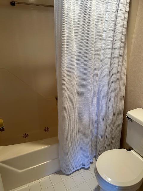 bathroom featuring shower / bath combo, tile patterned floors, and toilet