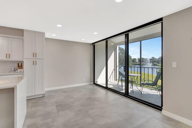 interior space with expansive windows and a water view