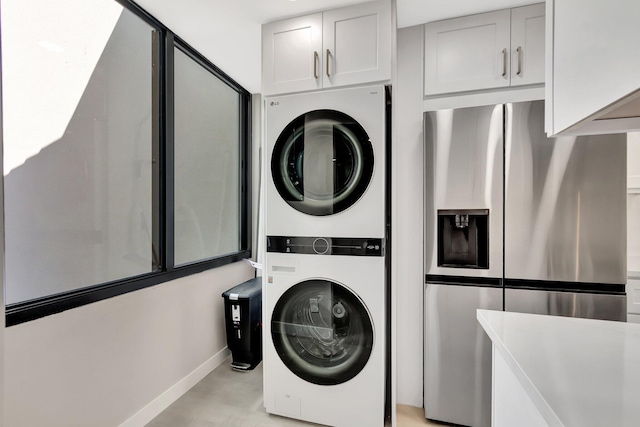 laundry area featuring stacked washer / drying machine