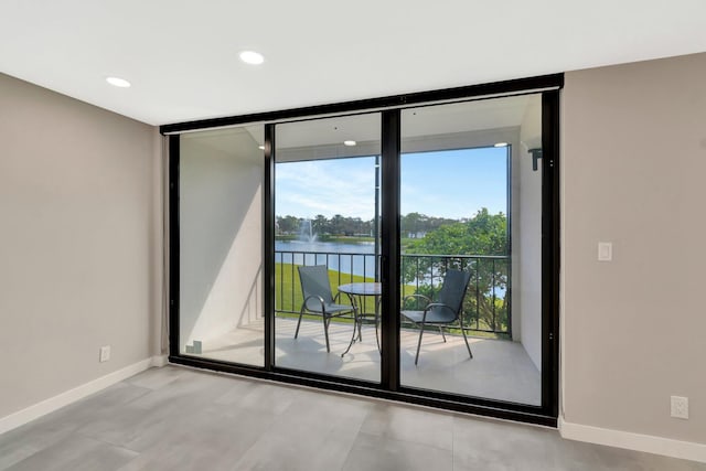 doorway with floor to ceiling windows and a water view