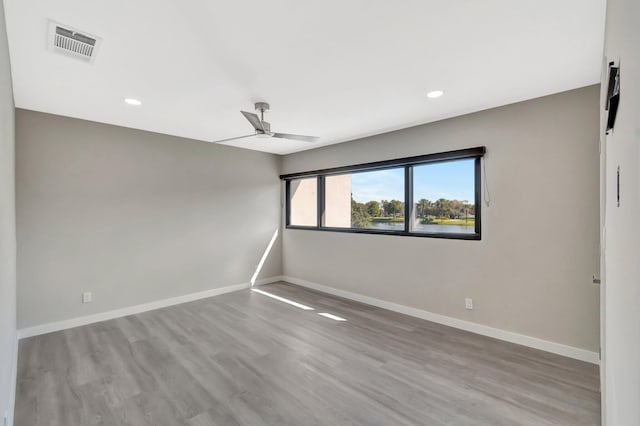 empty room with ceiling fan and light hardwood / wood-style floors