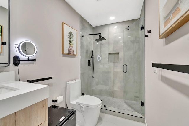 bathroom featuring vanity, toilet, and a shower with shower door