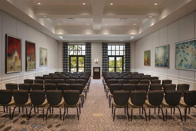 carpeted home theater room with beamed ceiling, coffered ceiling, and crown molding