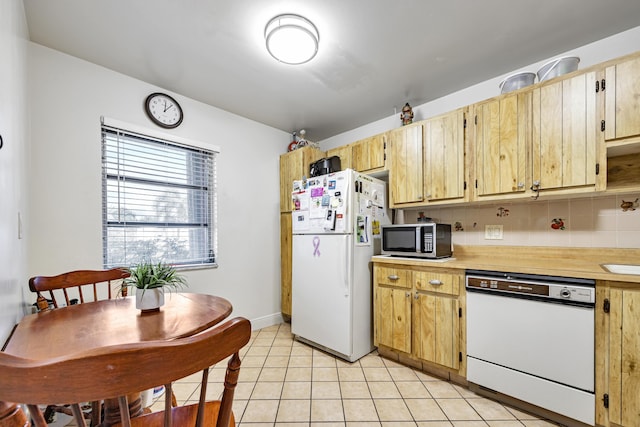 kitchen with light tile patterned floors, white appliances, and decorative backsplash