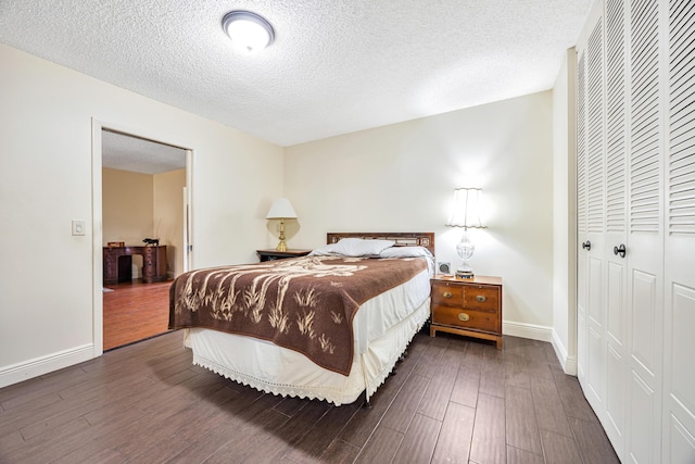 bedroom featuring a closet, dark hardwood / wood-style floors, and a textured ceiling