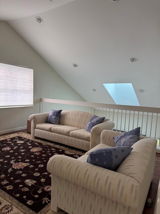 living room with vaulted ceiling with skylight