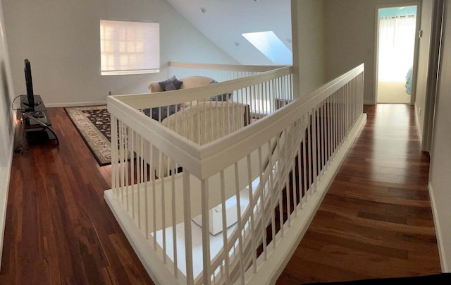 hall featuring dark hardwood / wood-style floors and lofted ceiling with skylight