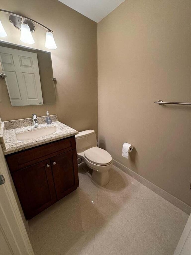 bathroom with vanity, tile patterned flooring, and toilet