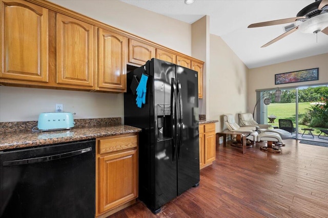 kitchen with dark wood-type flooring, vaulted ceiling, dark stone countertops, ceiling fan, and black appliances