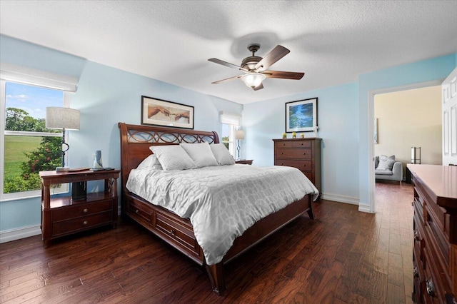 bedroom featuring dark wood-type flooring, ceiling fan, and a textured ceiling