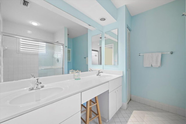 bathroom featuring tile patterned floors, vanity, and a shower with shower door