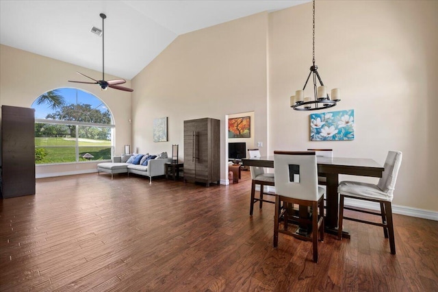 dining room with high vaulted ceiling, dark hardwood / wood-style flooring, and ceiling fan with notable chandelier