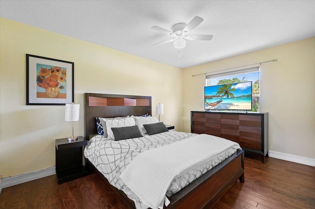 bedroom with ceiling fan, dark wood-type flooring, and a textured ceiling