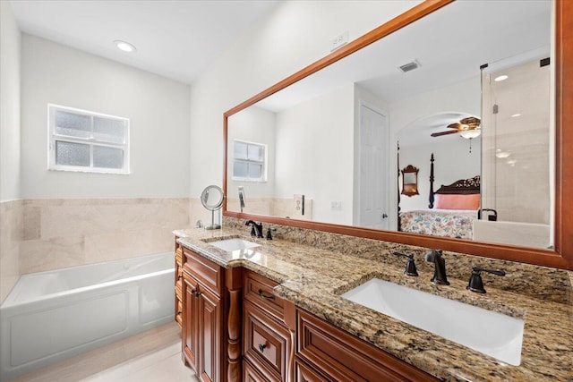 bathroom with vanity, a washtub, and ceiling fan