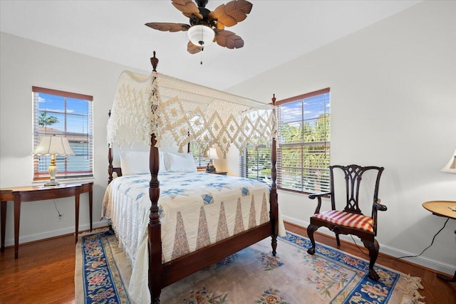 bedroom with multiple windows, wood-type flooring, and ceiling fan