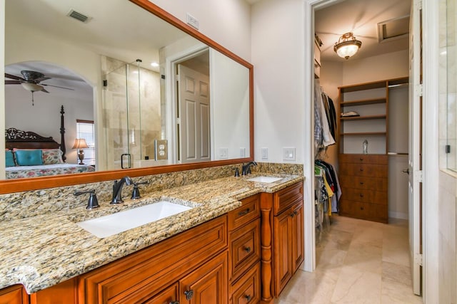 bathroom with vanity, ceiling fan, and walk in shower